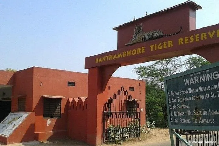 The red entrance gate to Ranthambore Tiger Reserve with a warning sign.